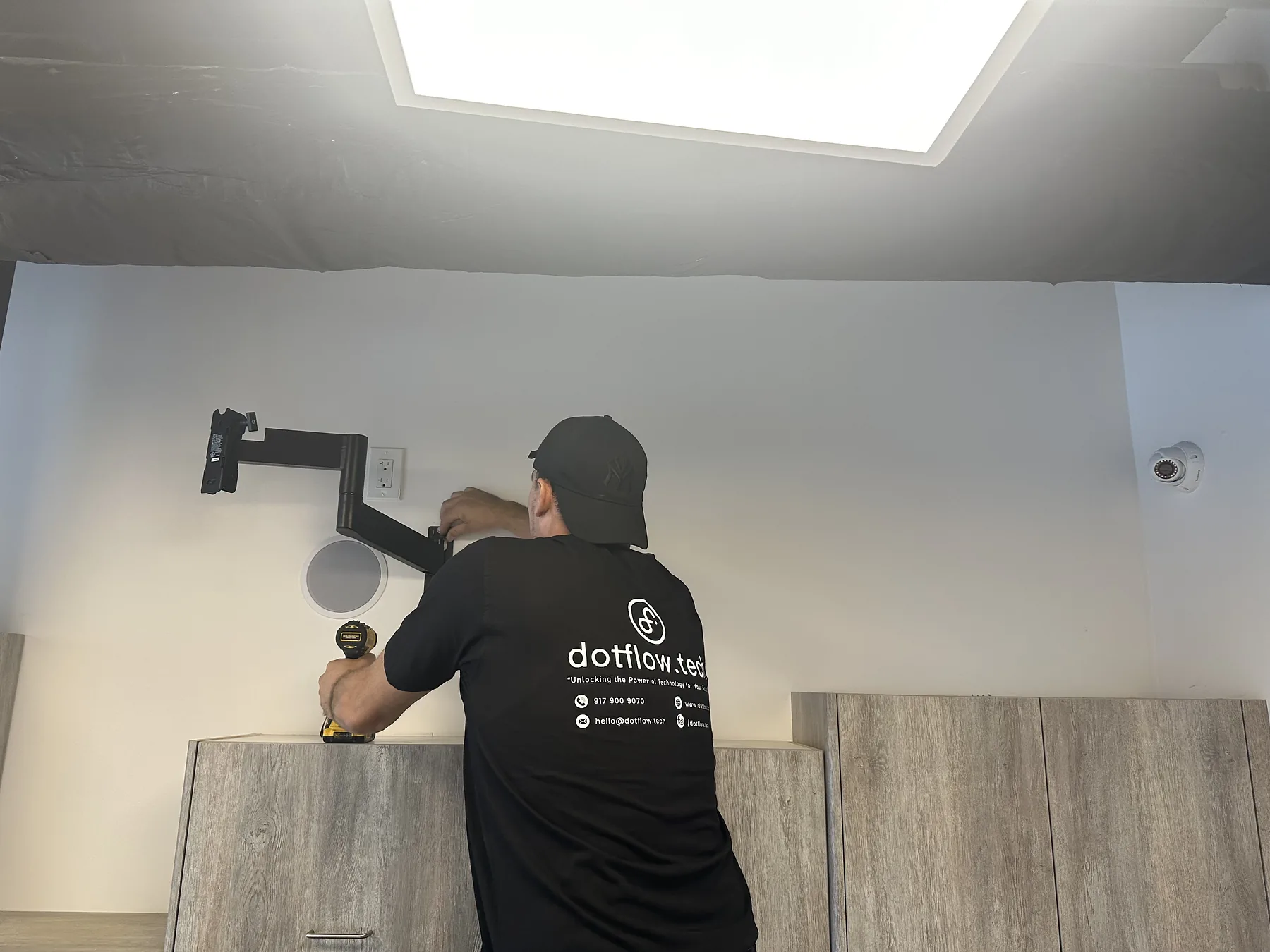 Technician installing an articulating TV wall mount
