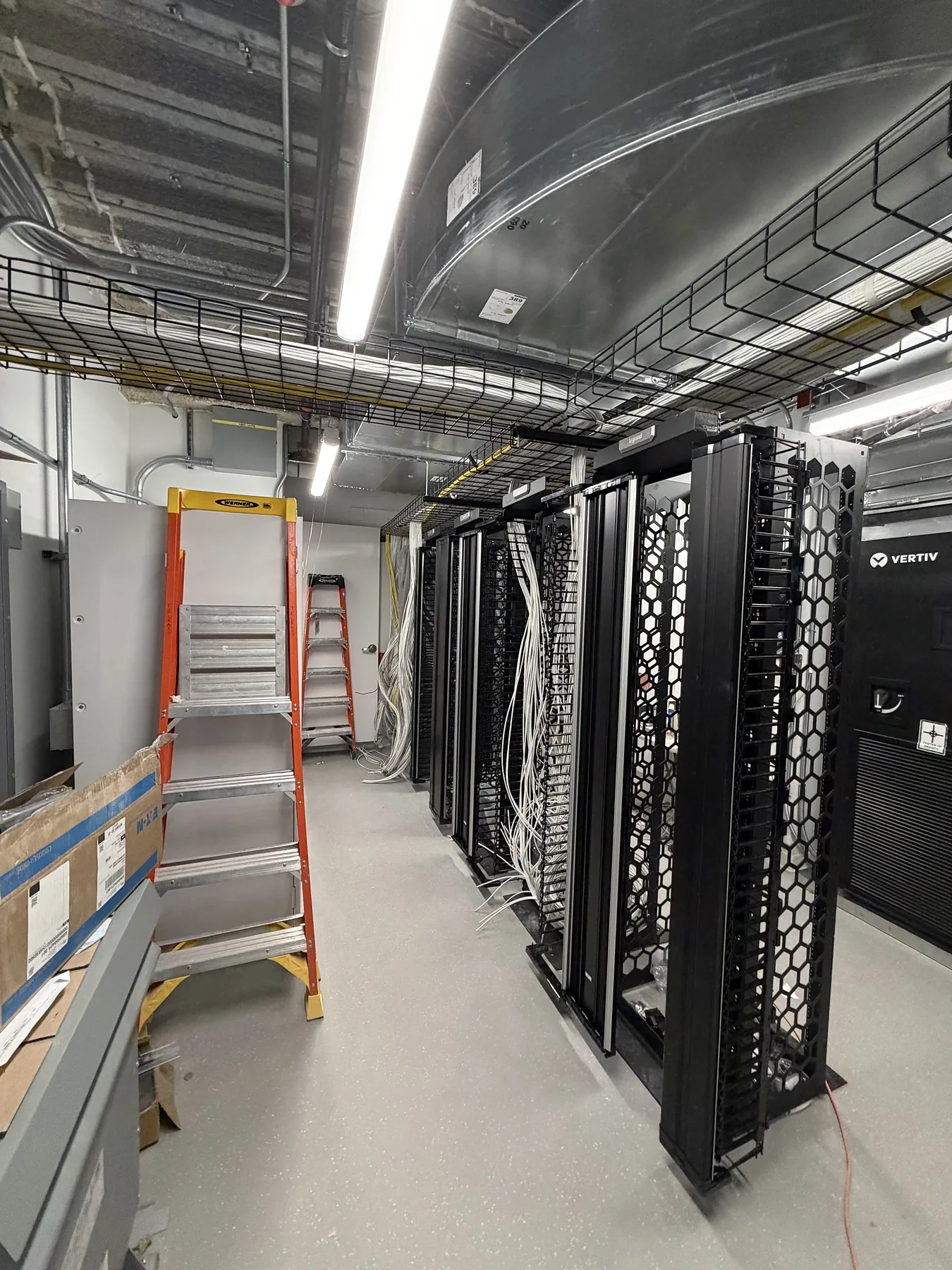 Open-frame server racks in a data room with stepladder
