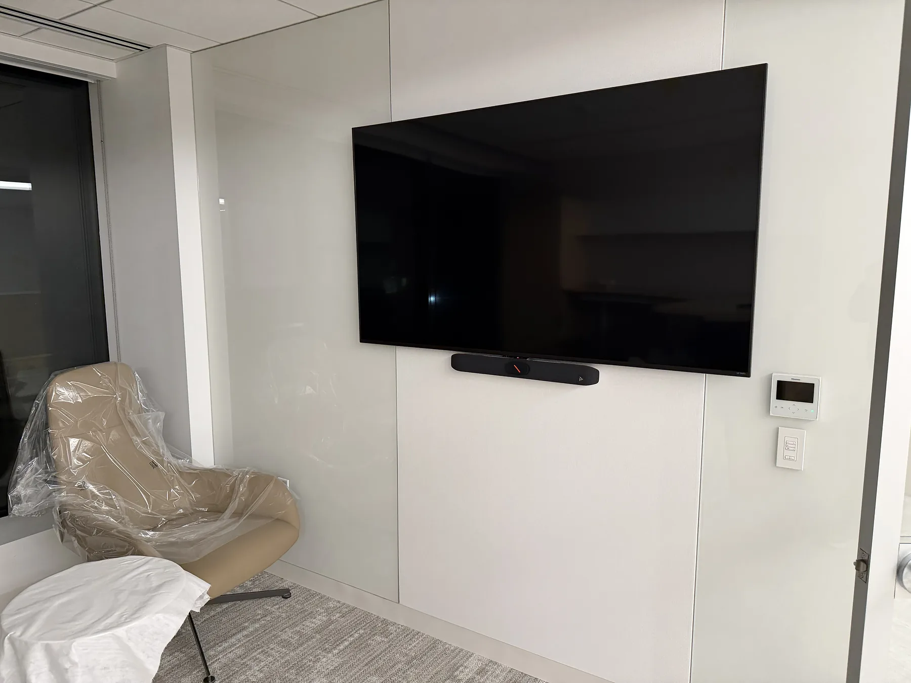 Wall-mounted office display with video conferencing soundbar