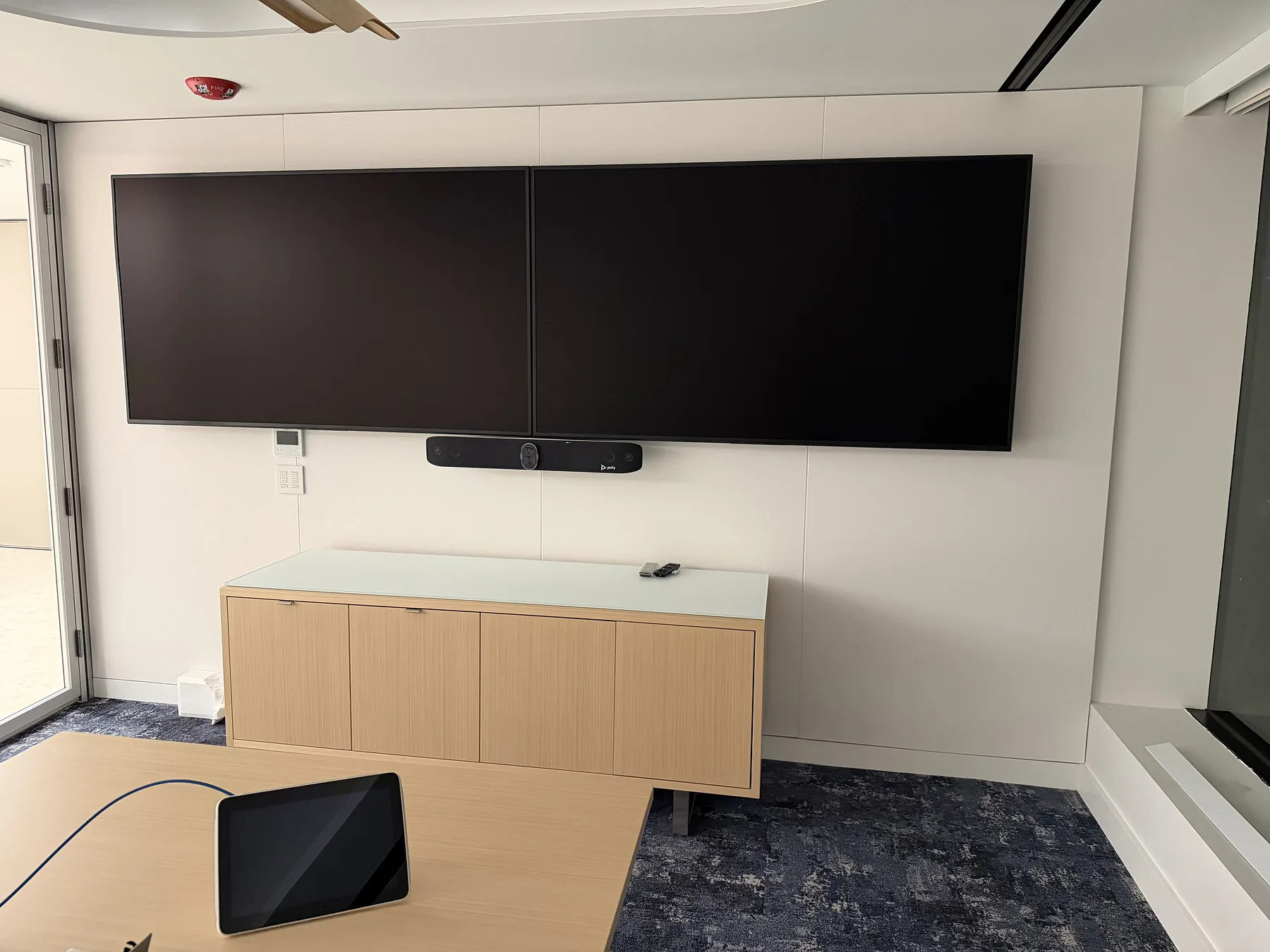 Dual meeting-room displays with soundbar and tabletop controller