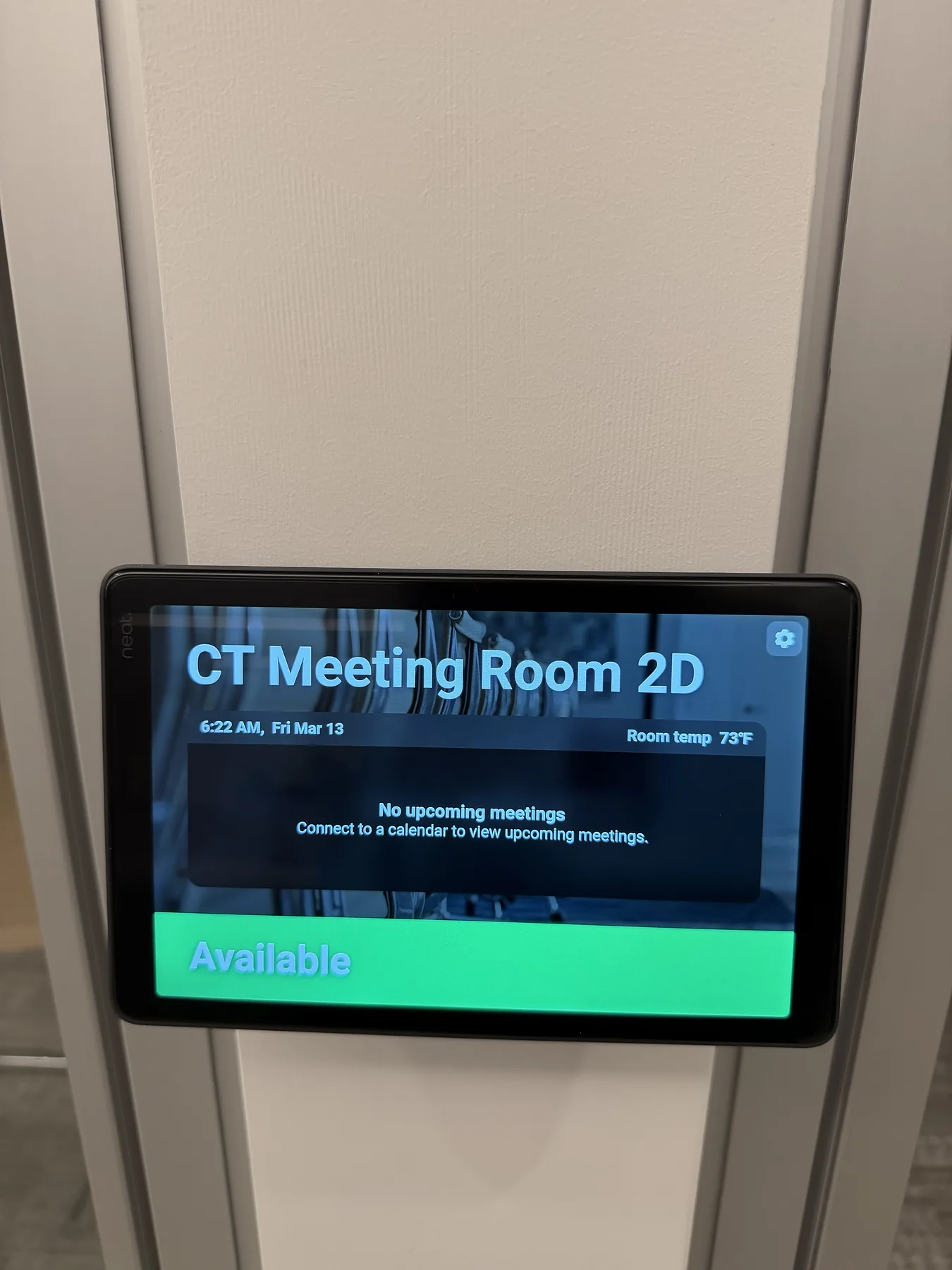 Wall-mounted meeting room scheduling display showing available