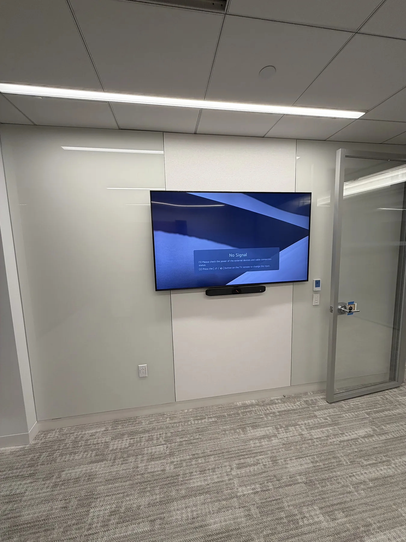 Wall-mounted office television displaying abstract graphics