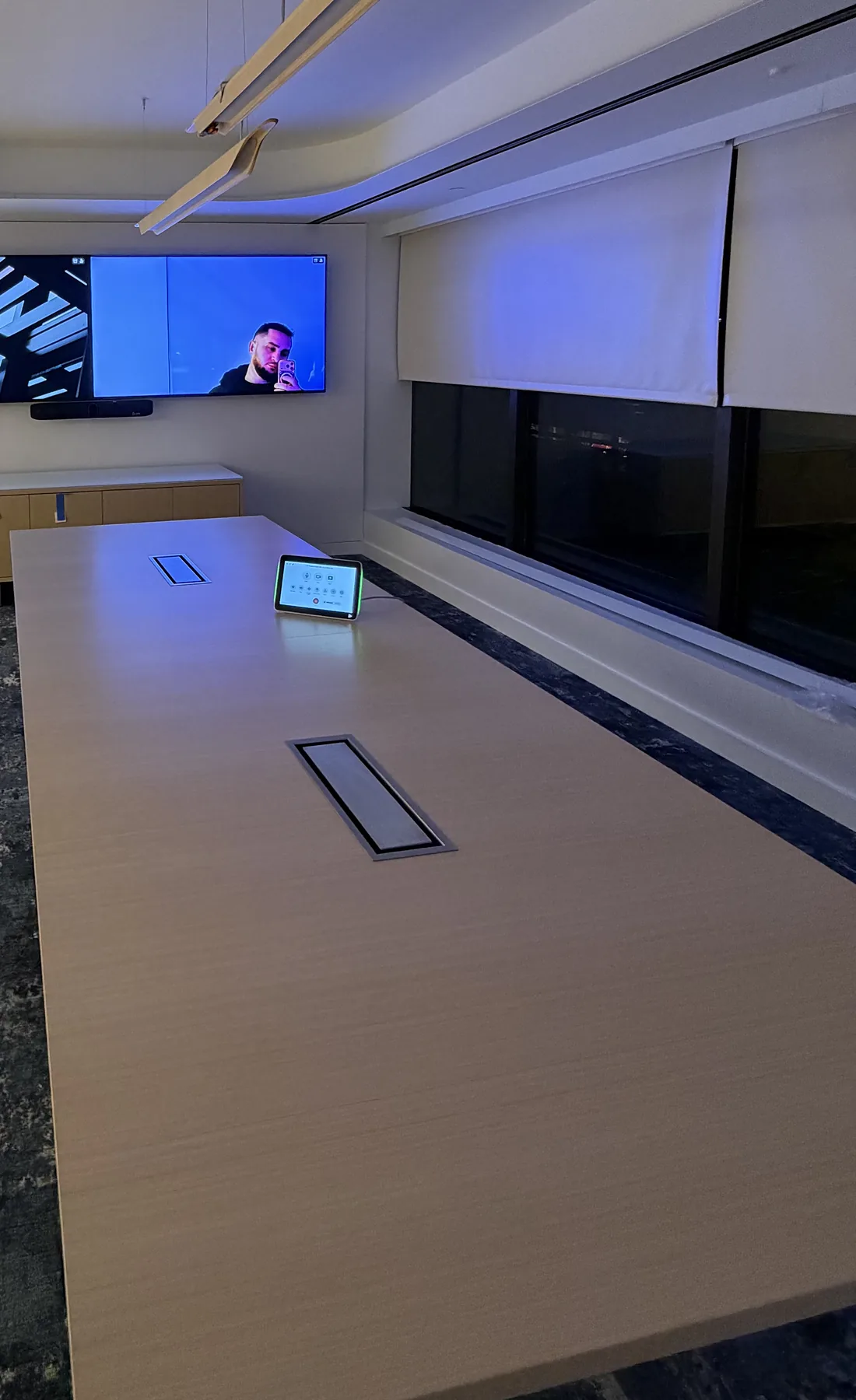Conference room with wall display, video bar, and tabletop control tablet