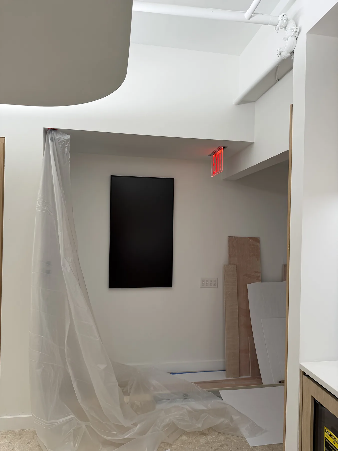 Room under construction with protective sheeting and wall panel