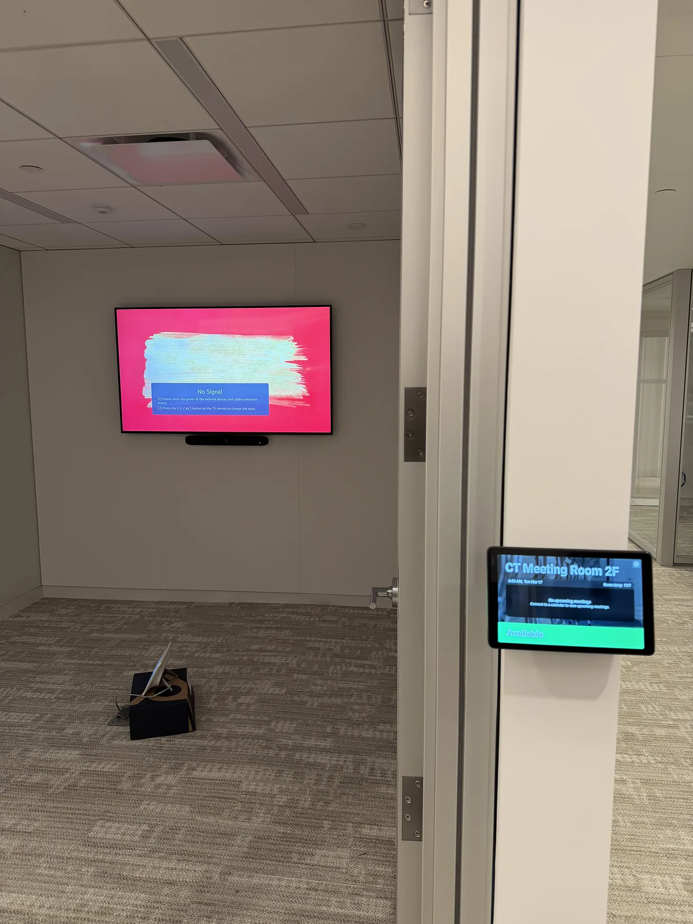 Meeting room view with door-frame scheduling display in foreground