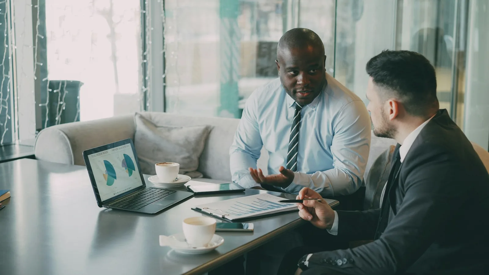Business meeting with charts on a laptop