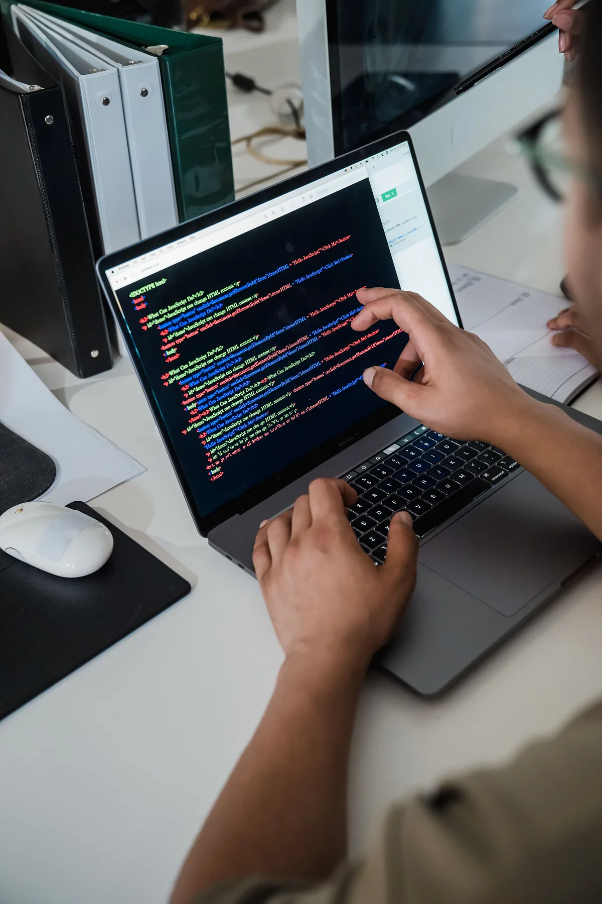Hands typing code on a laptop