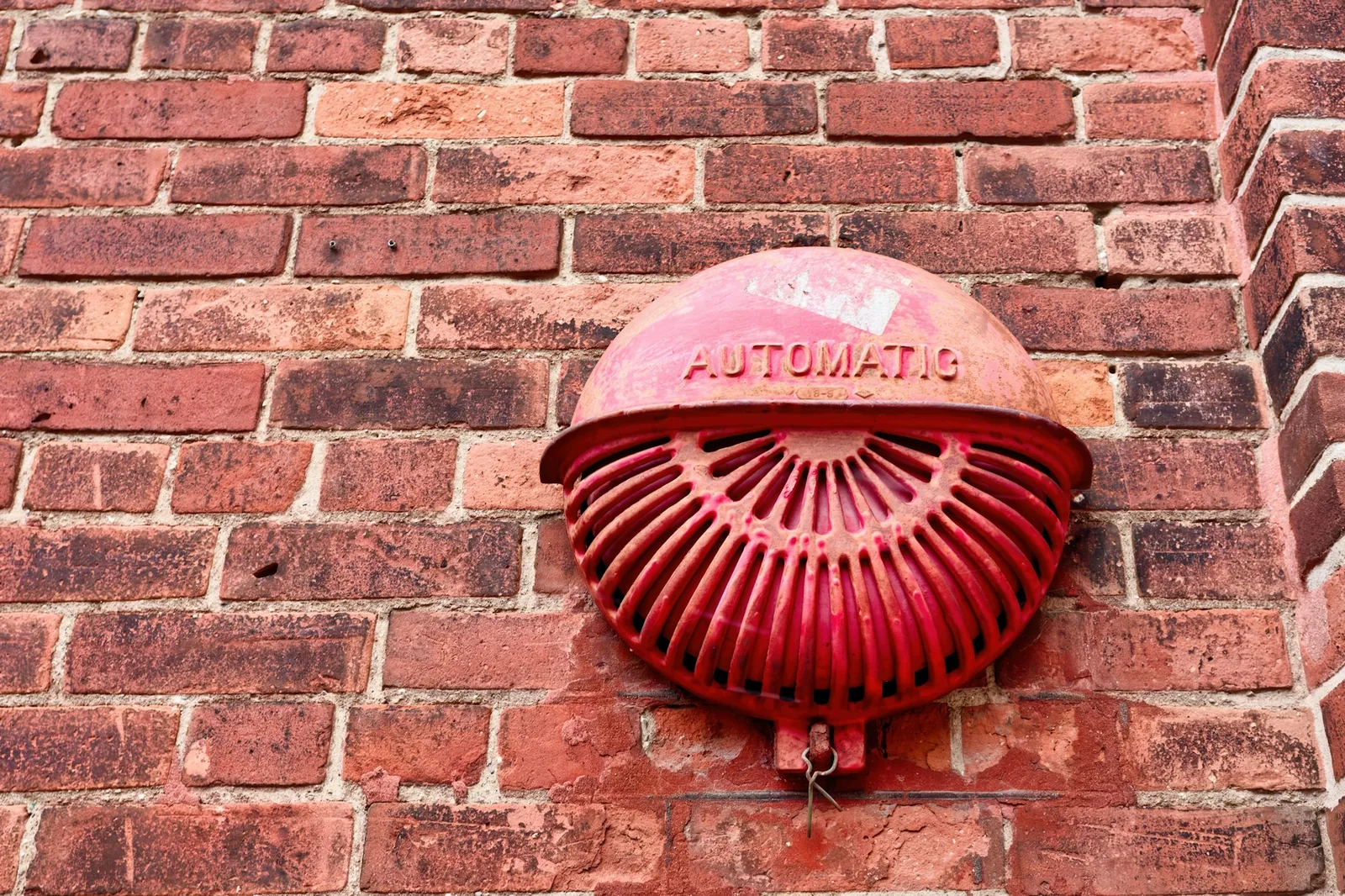 Fire alarm bell mounted on a brick wall