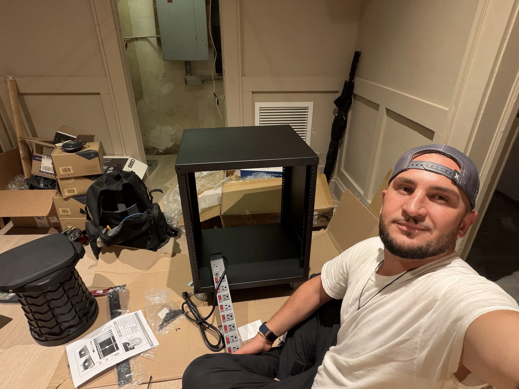 Technician assembling a small open-frame equipment rack on the floor