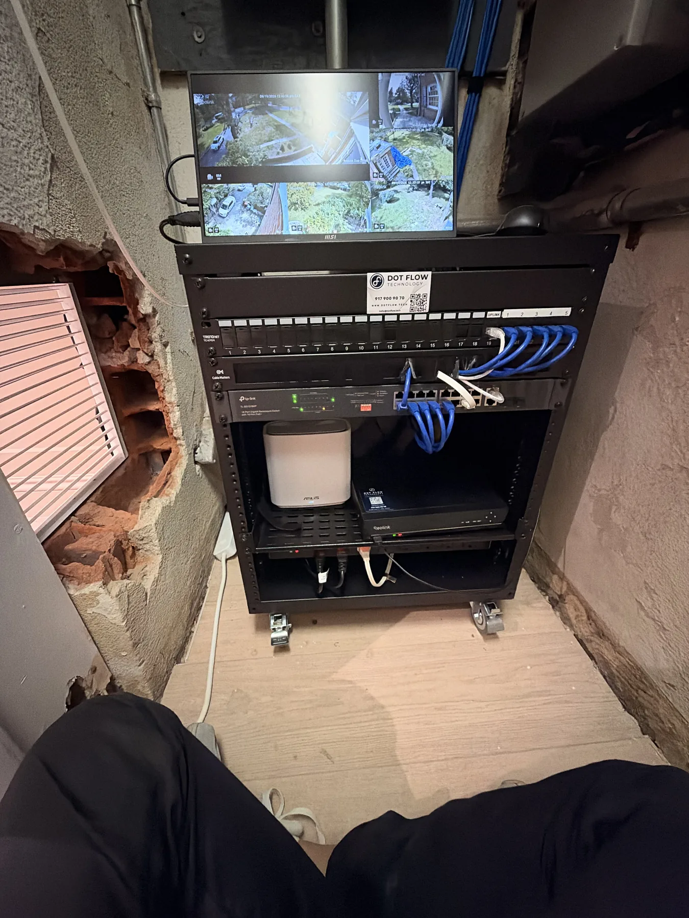 Wall network closet with patch panel and blue Ethernet cables