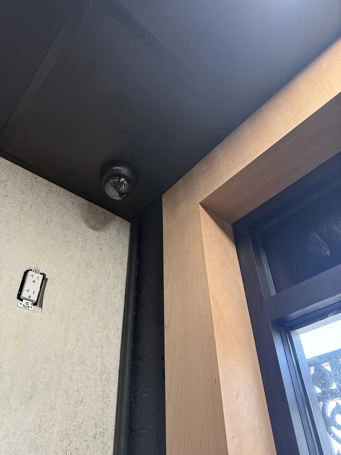 Black dome security camera under an outdoor soffit