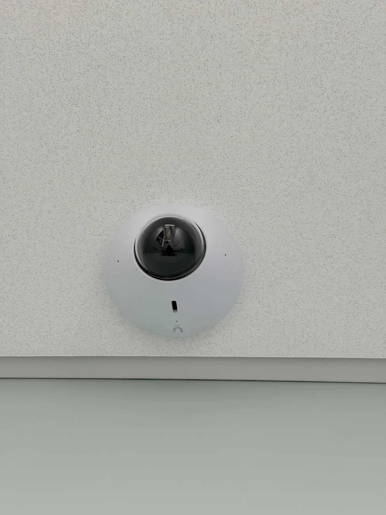 White ceiling-mounted dome security camera