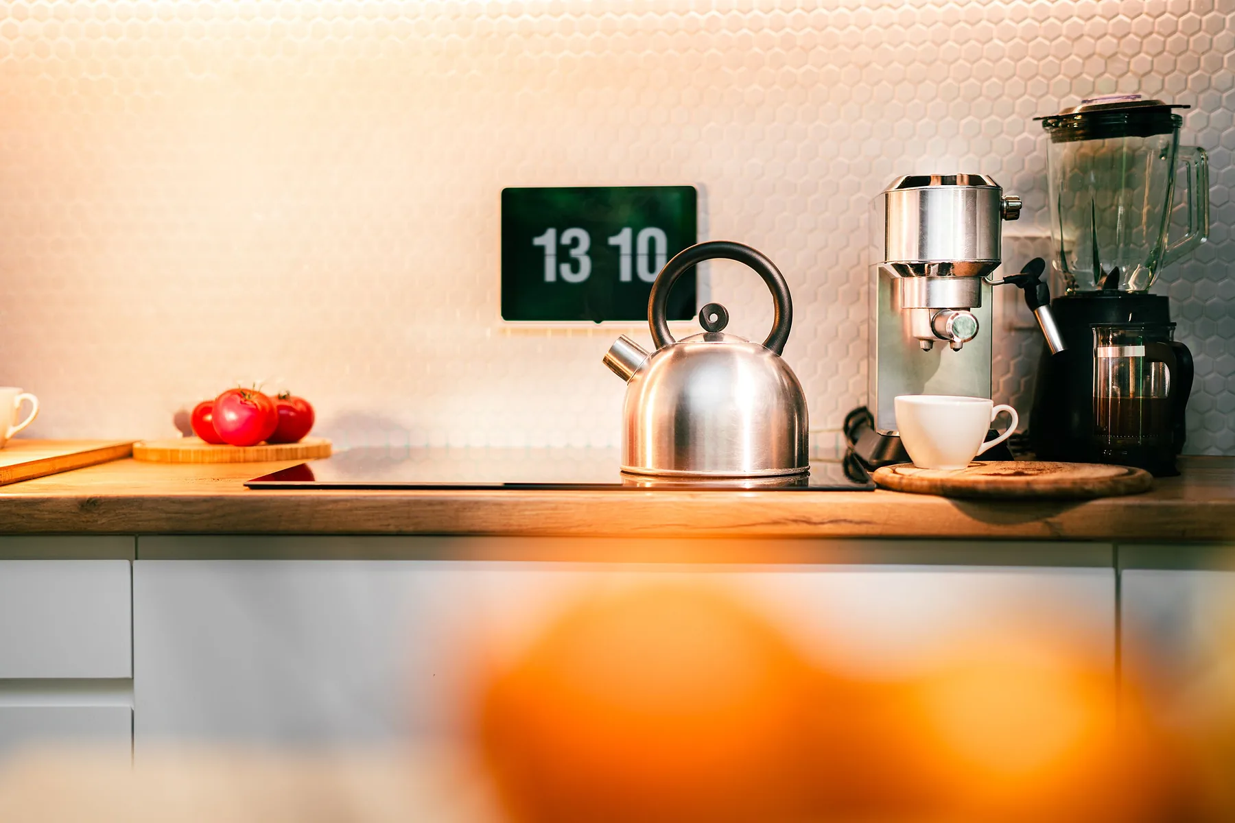 Kitchen appliances and digital wall clock on a countertop