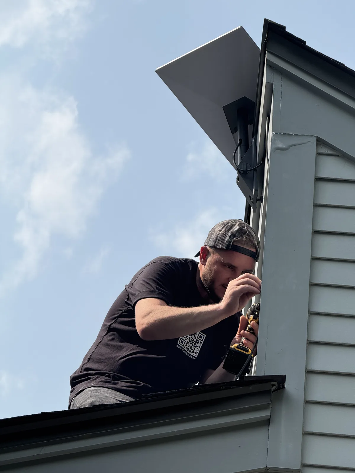 Technician installing a Starlink dish on a roof
